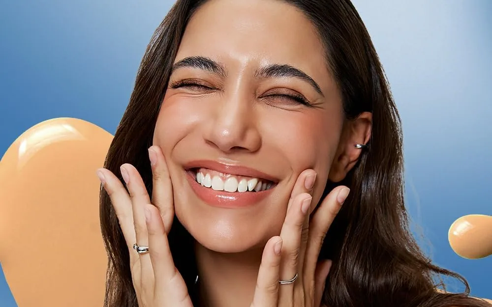 A smiling model with her hands on her cheeks wearing TFIT Idol Cover Concealer