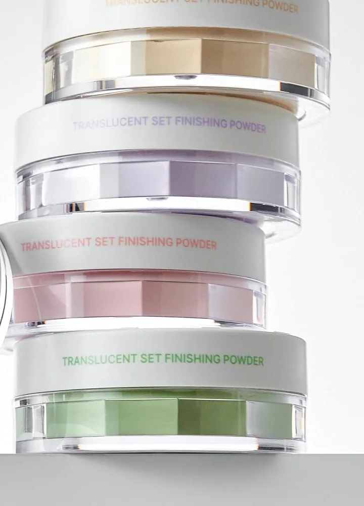 A stack of TFIT Translucent Set Finishing Powder jars in beige, lavender, pink and green