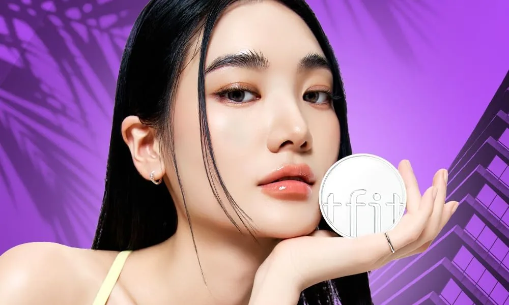 A model holding the TFIT finishing powder jar next to her cheek